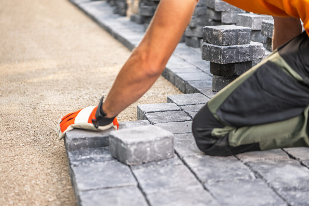 laying paving stones on a pathway in bright daylight